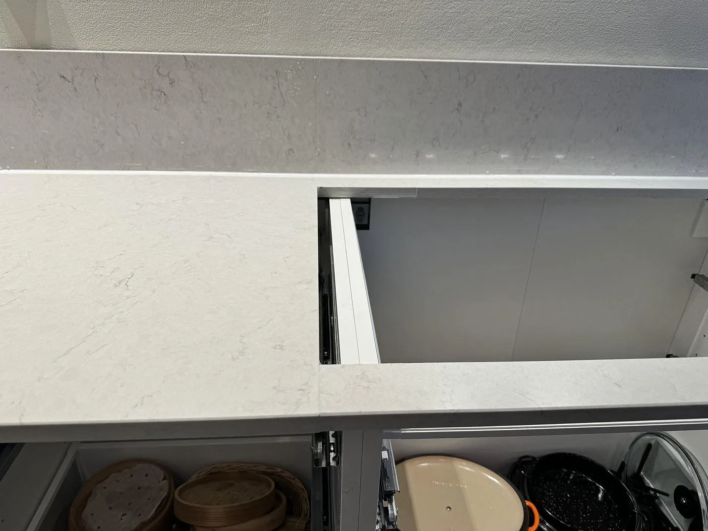 Detalj av skarv och urtag i polerad Silestone Snowy Ibiza ovanför öppna lådor och stänkkant i Västra Frölunda.