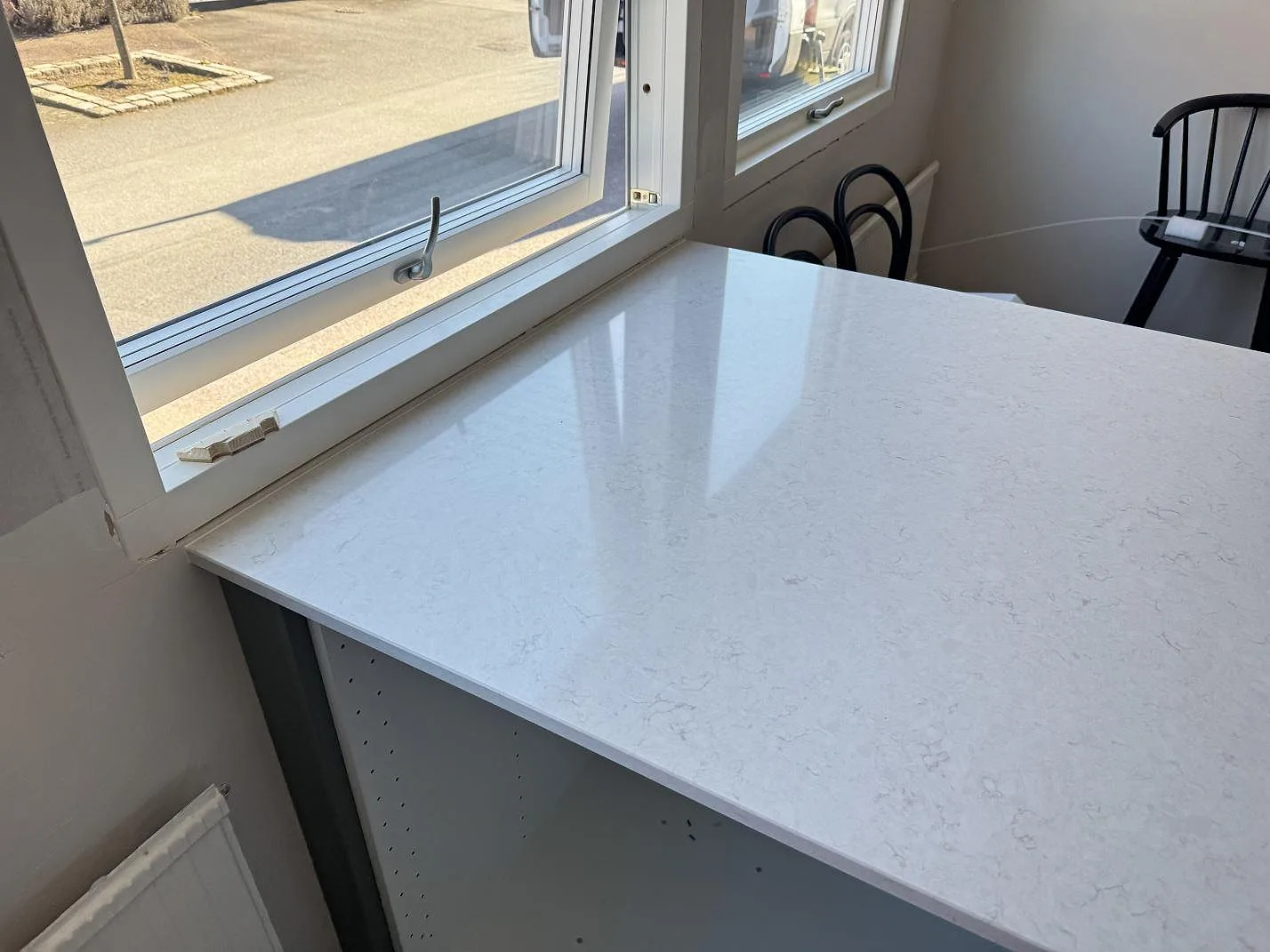Fönsternära arbetsyta i polerad Silestone Snowy Ibiza kvartskomposit med blank reflektion och ljus ådring i Västra Frölunda.