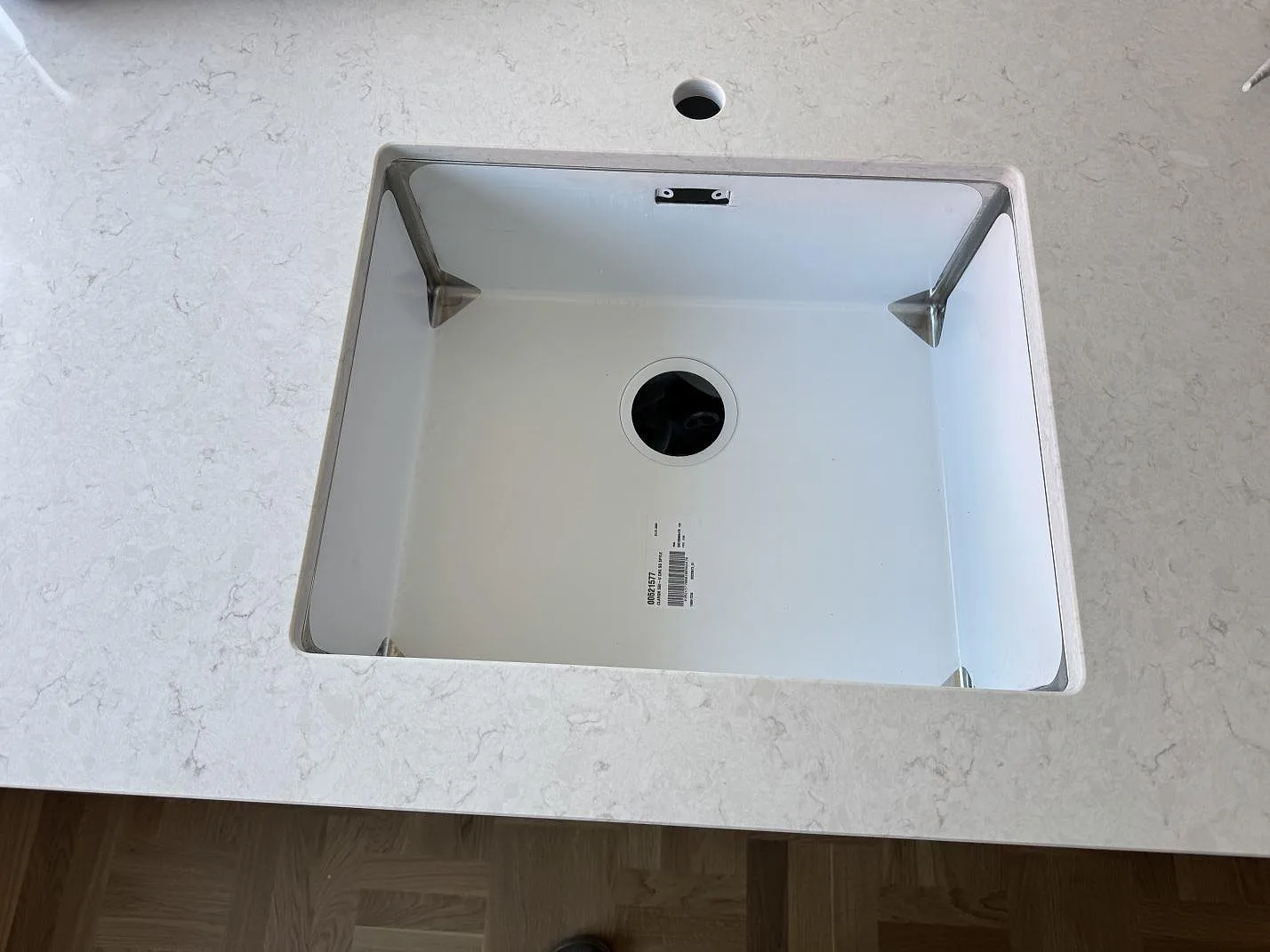 Diskhoparti i polerad Silestone Snowy Ibiza kvartskomposit med ljus sten runt diskhon i ett kök i Västra Frölunda.
