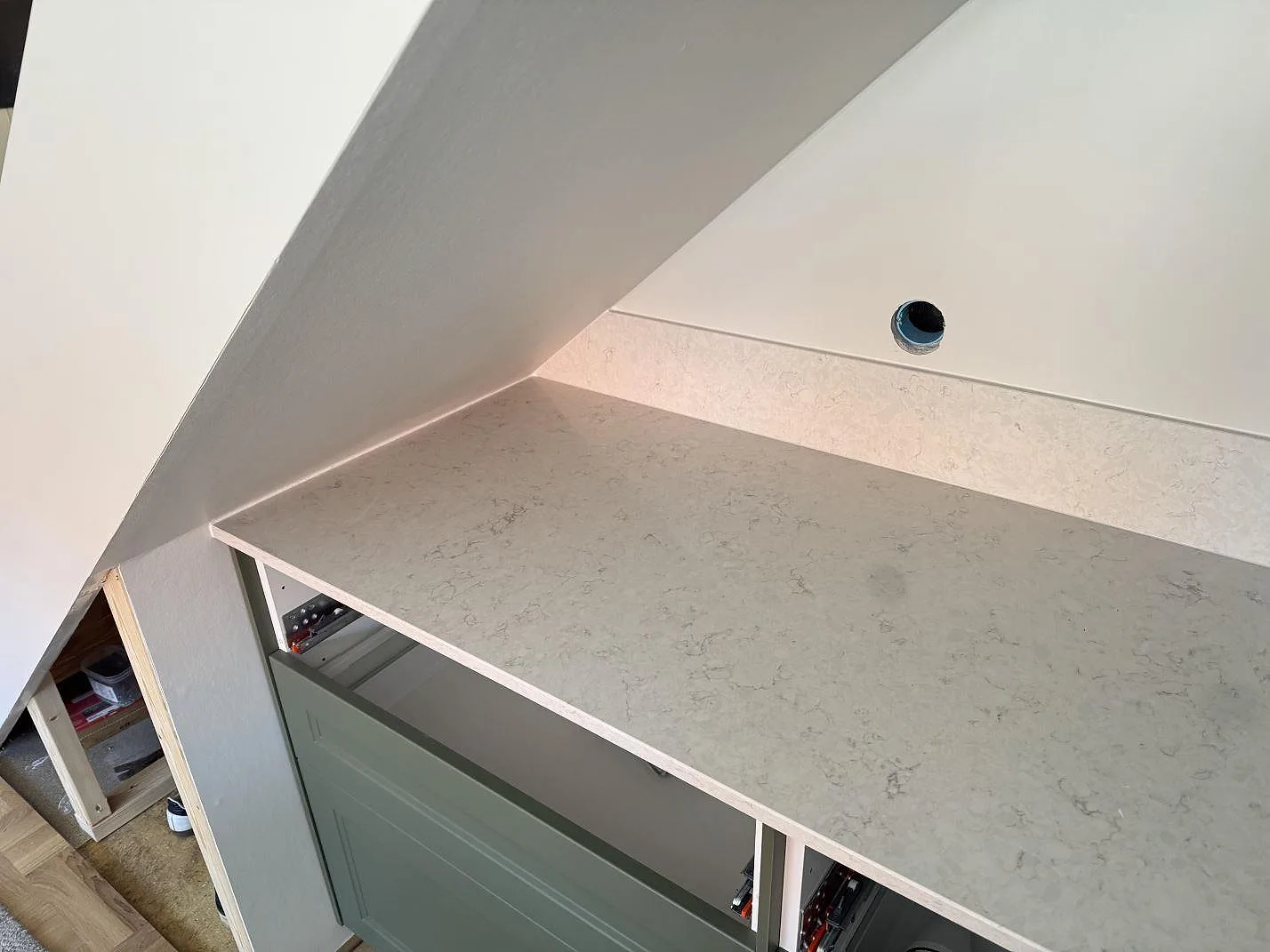 Sidovy av polerad Silestone Snowy Ibiza kvartskomposit med 12 mm stänkskydd och öppna stommar under montering i Västra Frölunda.
