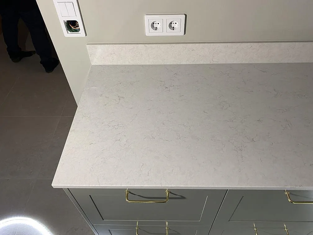 Polerad Silestone Snowy Ibiza köksbänkskiva av kvartskomposit med stänkskiva och eluttag i Växjö.