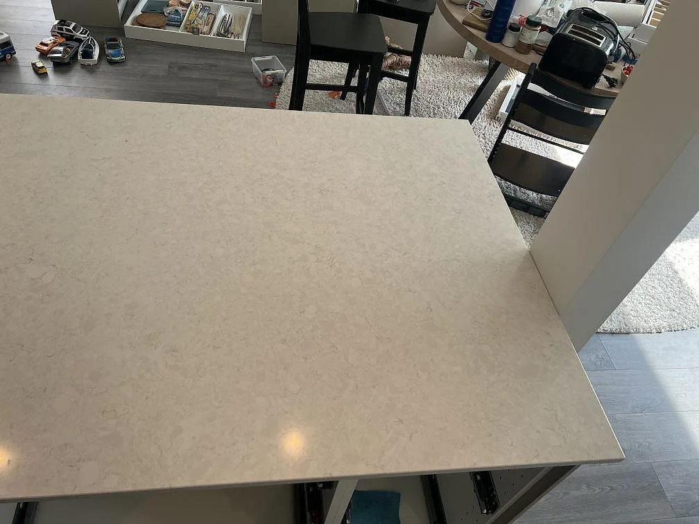 Detalj av polerad Silestone Snowy Ibiza komposit på köksö med synlig ljus ådring och rak kant i Veberöd.