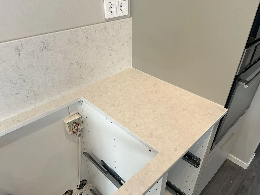 Hörndetalj av polerad Silestone Snowy Ibiza bänkskiva och stänkskydd vid öppna köksstommar i Veberöd.