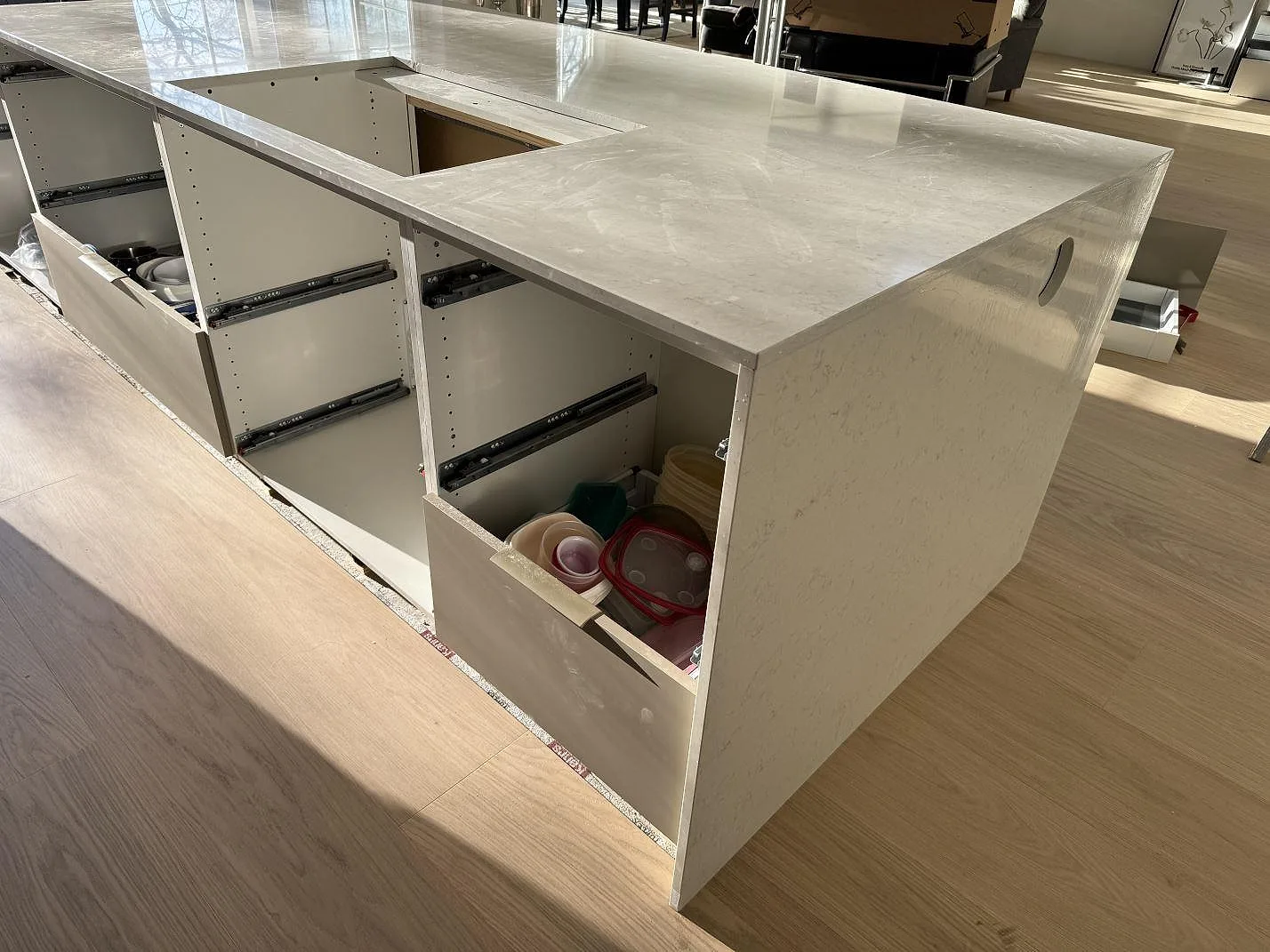 Baksida av köksö med polerad Silestone Snowy Ibiza, grå stommar och vattenfallsida i Vejbystrand.