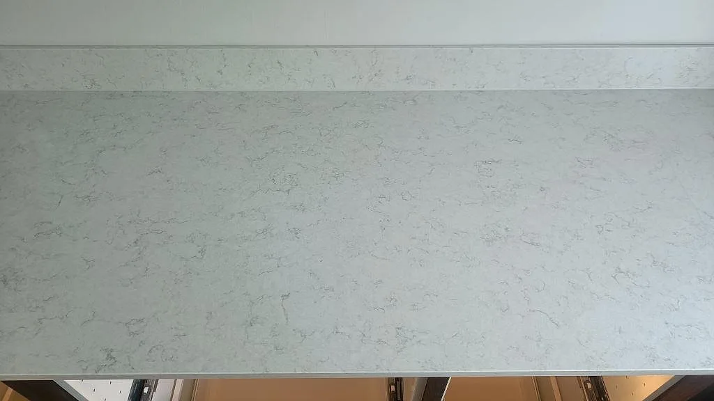 Polerad yta i vit Silestone Snowy Ibiza med diskret grå ådring på en köksbänkskiva i Vellinge.
