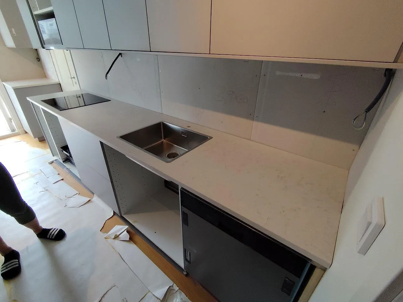 Köksbänkskiva i vit Silestone Snowy Ibiza, matt Mocka, med underlimmad rostfri diskho och häll i ett kök i Vendelsö.
