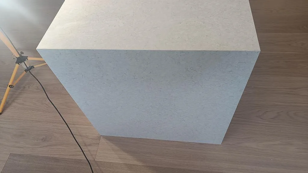 Detalj av köksöns stenklädda sida och polerade topp i Silestone Snowy Ibiza i ett kök i Viken.