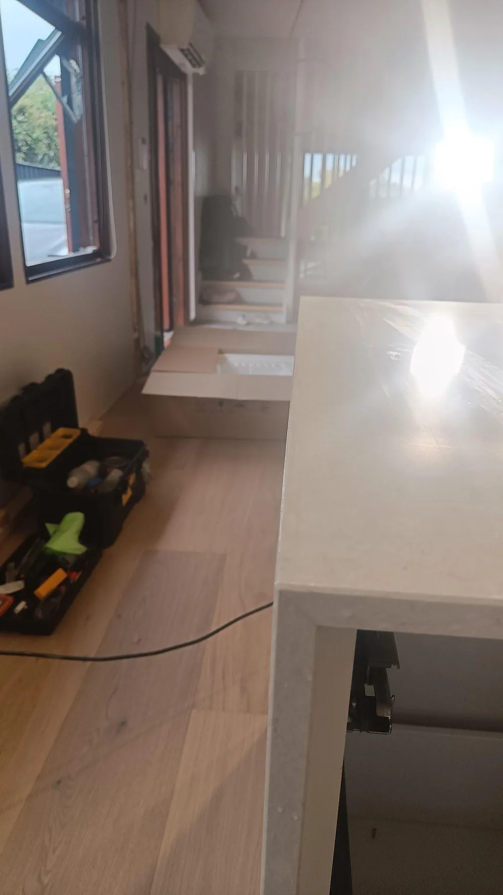 Sidodetalj av polerad Silestone Snowy Ibiza på köksön under montering, med blank ljus yta i ett kök i Viken.
