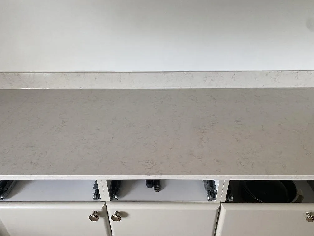 Ytdetalj av polerad Silestone Snowy Ibiza som köksbänkskiva med diskret grå ådring och låg stänkkant i Ystad.