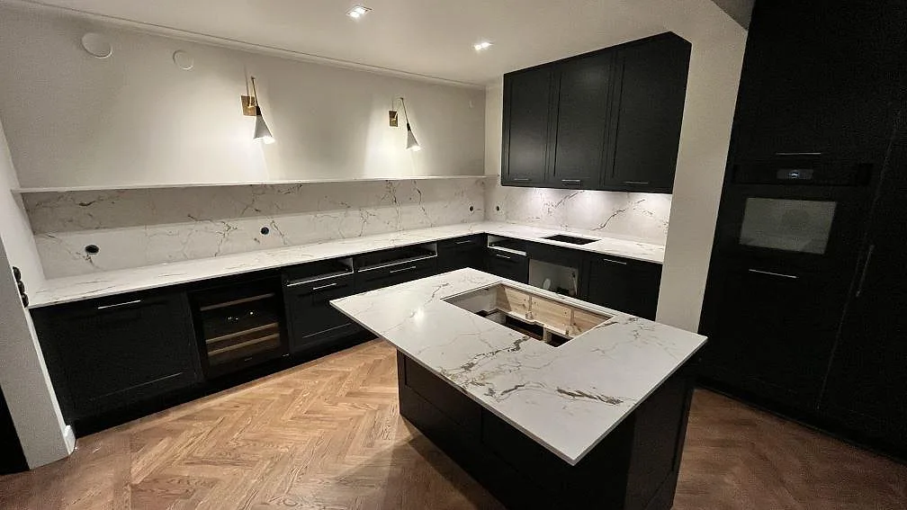 Köksbänkskiva i vit marmorlik komposit, Silestone Versallies Ivory, polerad, med köksö, väggbänkar och stänkskydd i Sigtuna.