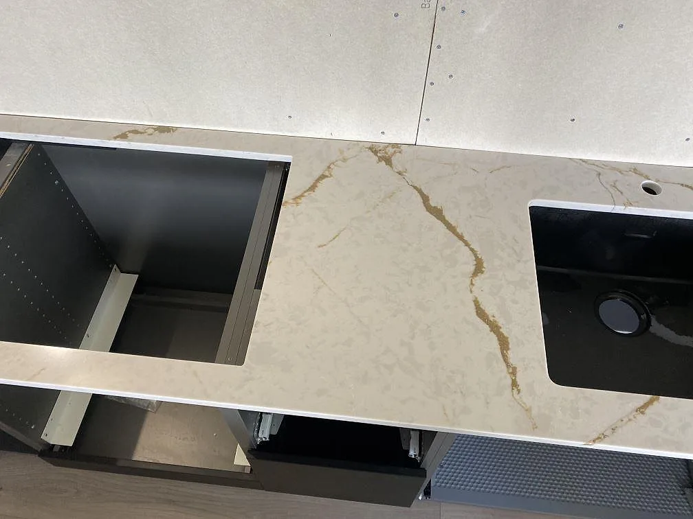 Detalj av polerad Silestone Versallies Ivory med hälluttag, svart diskho och blandarhål i Varberg.