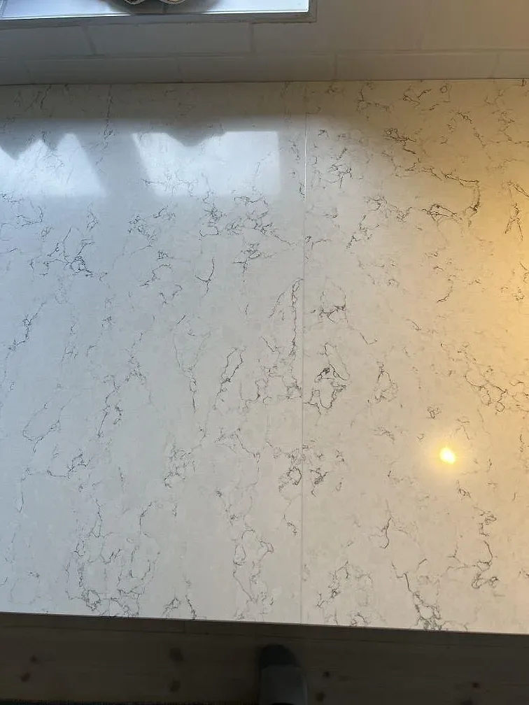Detalj av den polerade Silestone White Arabesque ytan med vit grund och grå ådring i ett kök i Villands Vånga.