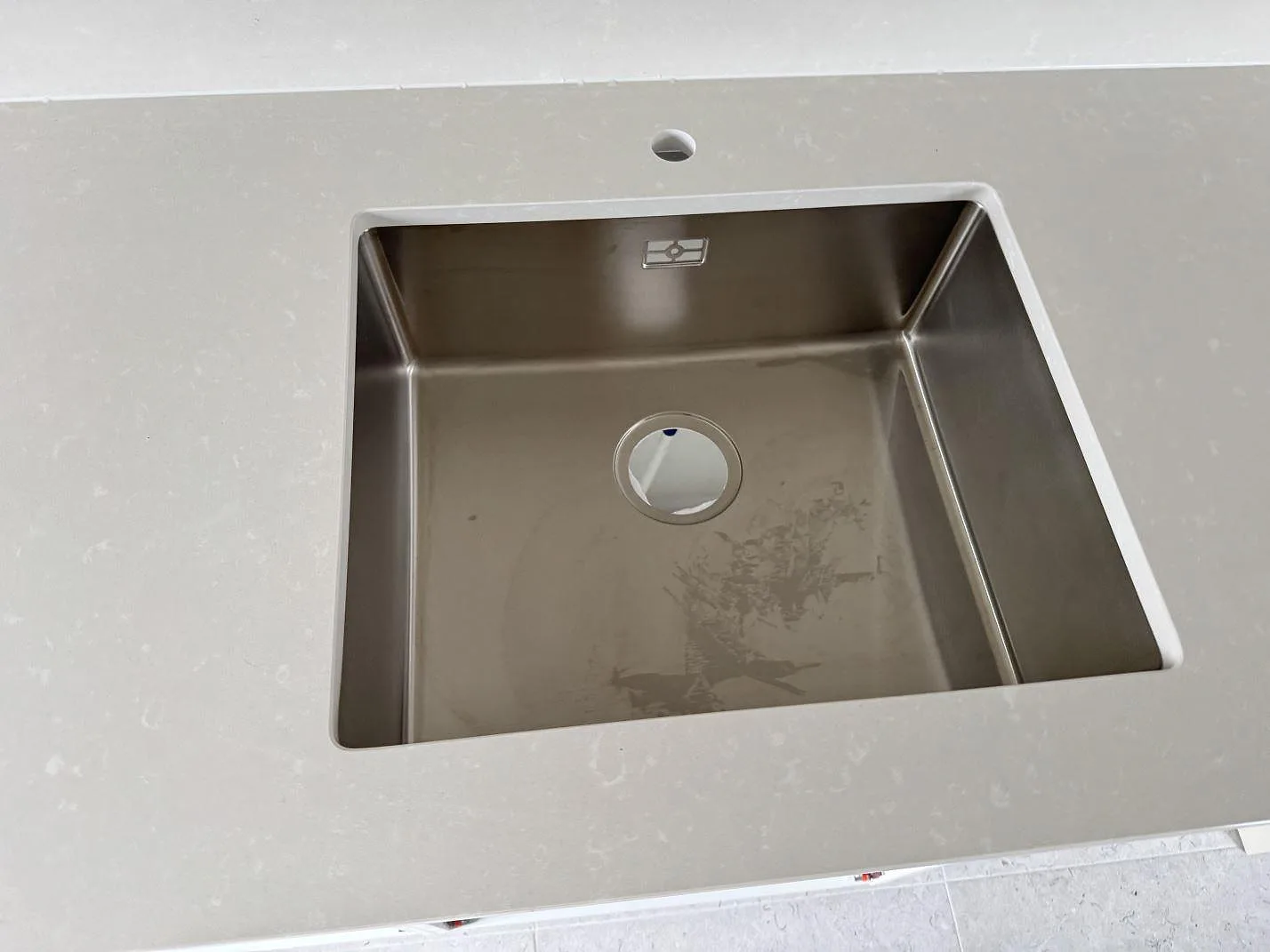 Närbild av rostfri diskho i en polerad Silestone Yukon kompositbänkskiva i Råå.