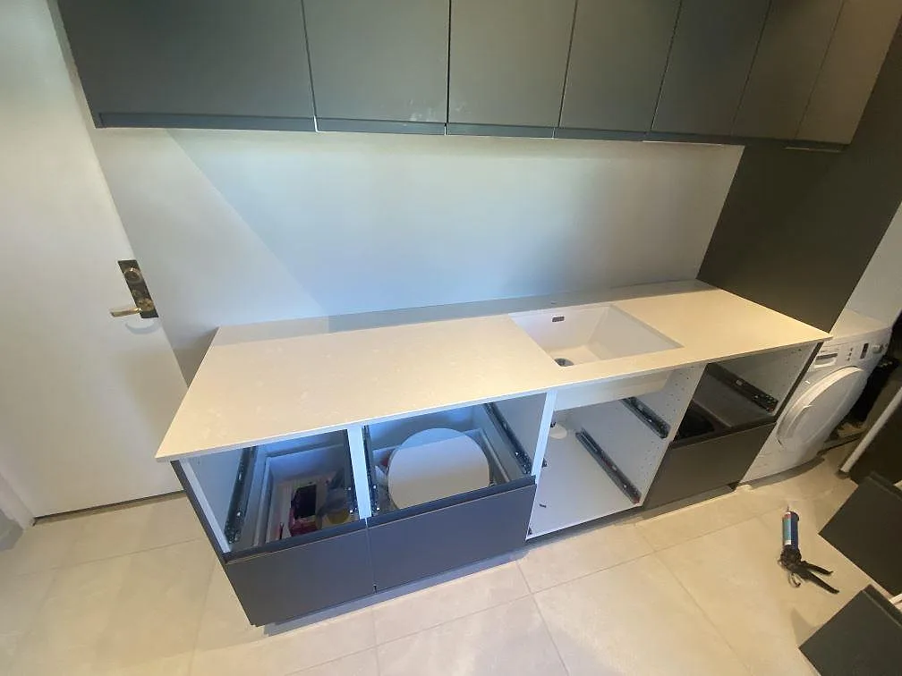 Köksbänkskiva i beige Silestone Yukon, polerad, med underlimmad diskho i ett kök med grå luckor i Ystad.