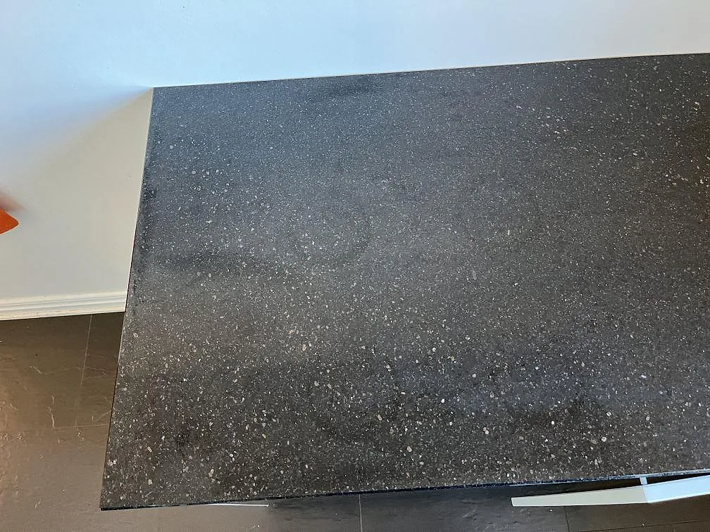 Detalj av den polerade ytan på en svart Star Galaxy granitbänkskiva i Göteborg, med tät strössel av glittrande guld- och silverkristaller.