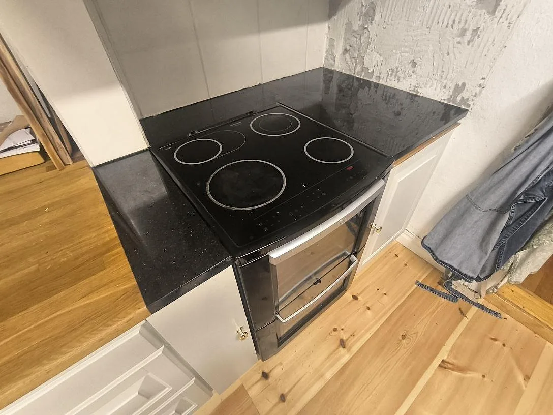 Polerad Star Galaxy granit som köksbänkskiva vid spisen, med mörk stenyta och ljusa mineralinslag i Grangärde.