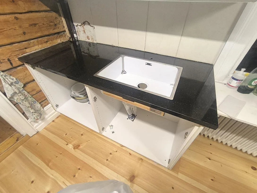 Köksbänkskiva i polerad Star Galaxy granit med vit diskho och synlig svart stenyta i Grangärde.