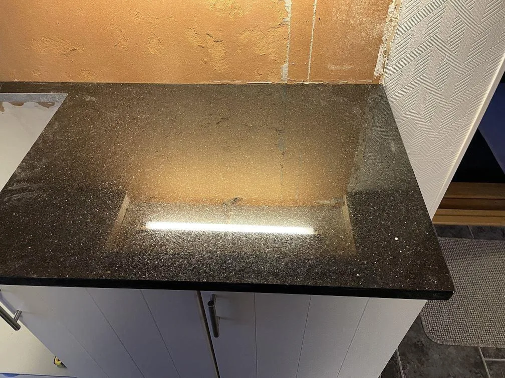 Detalj av Star Galaxy granitbänkskiva med fönsterbänk i samma sten i ett kök i Ödsmål.