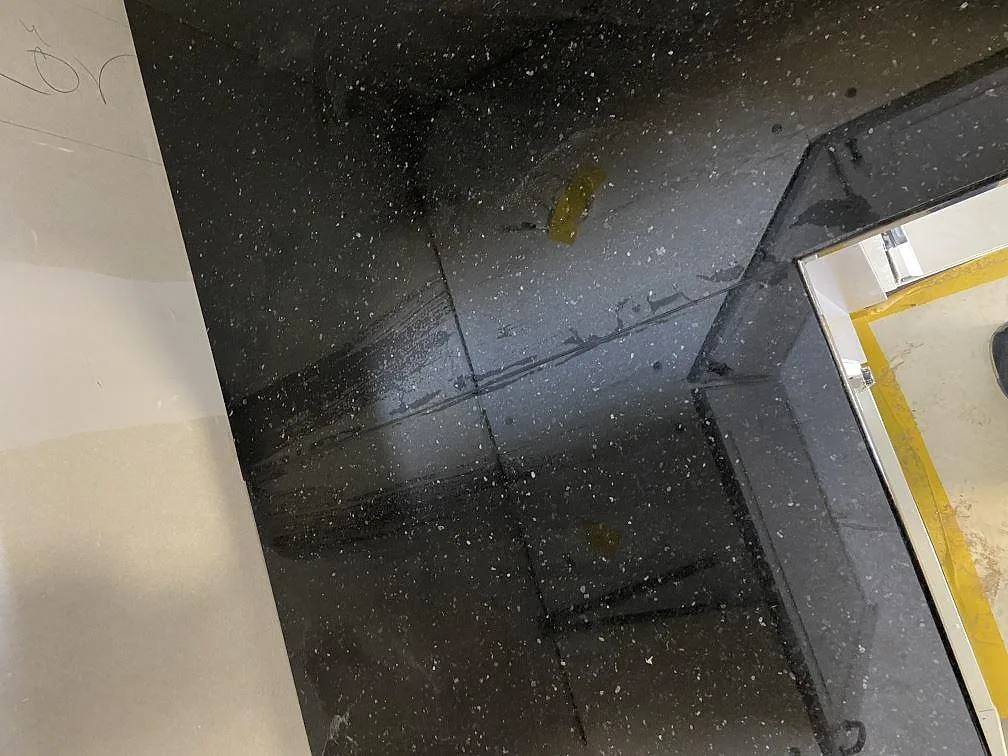 Närbild på den polerade ytan på Star Gate granit med silvervita kvartskorn i ett kök i Johannishus.