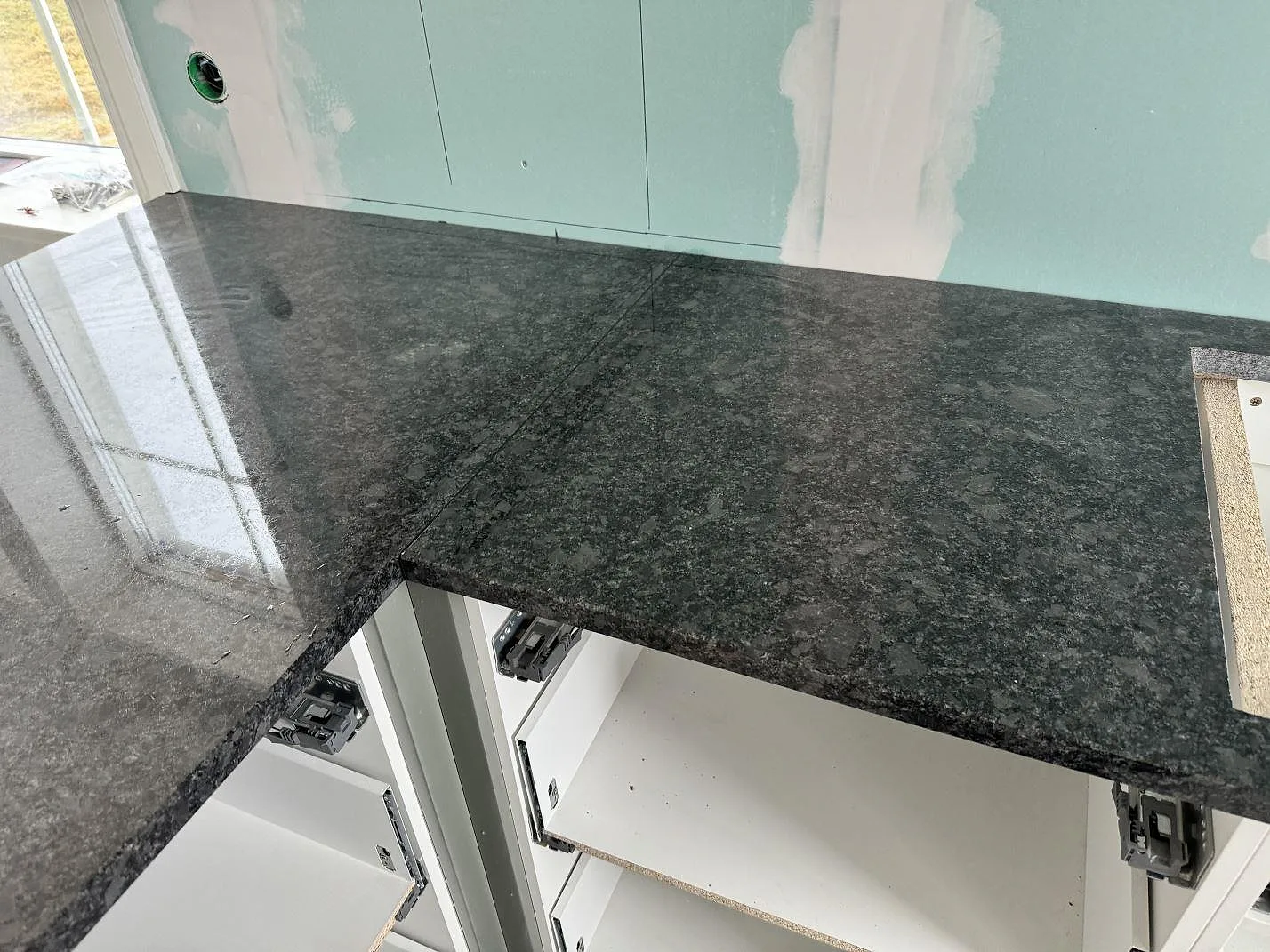 Närbild av polerad Steel Grey granit med öppen köksstomme och blank stenreflex i Älmestad.