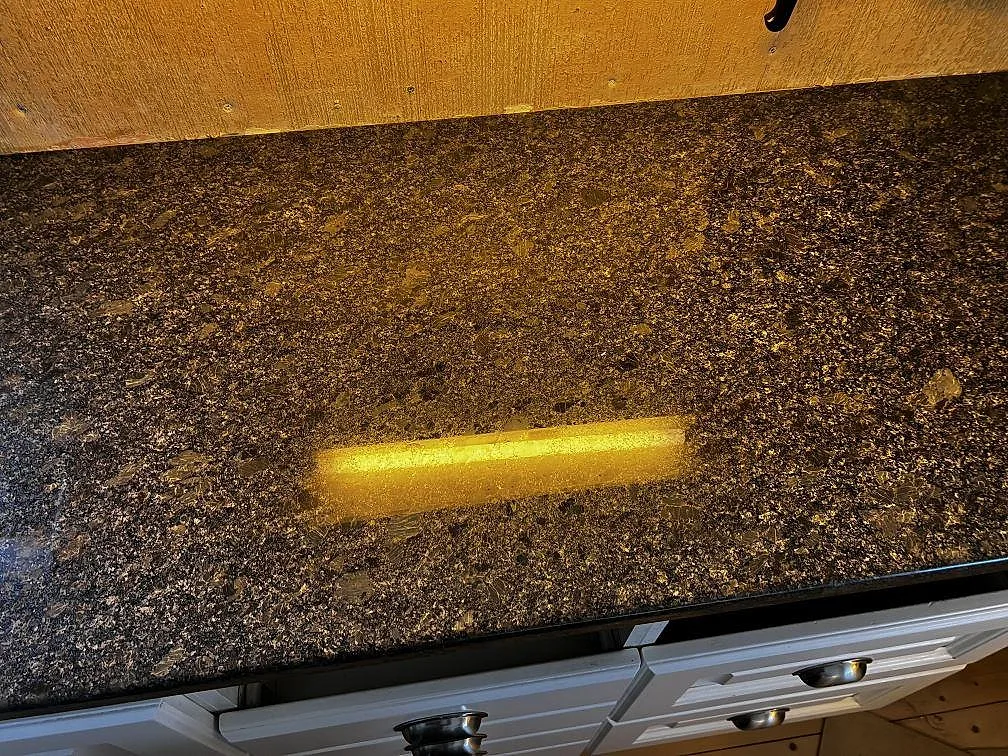 Detalj av polerad Steel Grey granit på köksbänk i Borås, där den mörka ytan visar stenens fläckiga naturmönster.