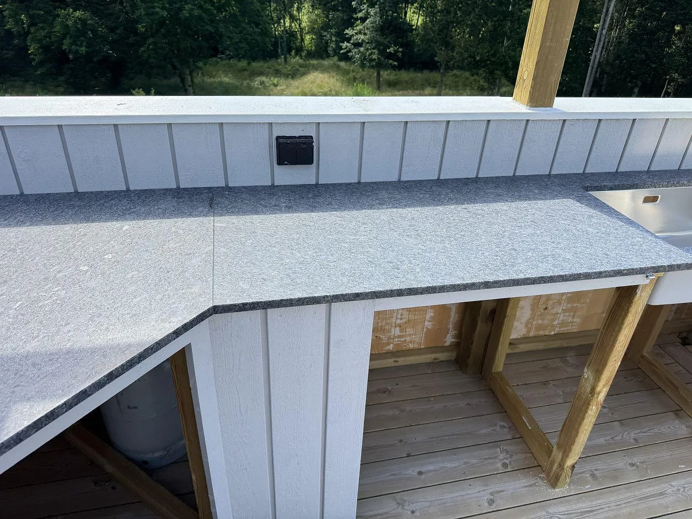 Rak vy över Steel Grey granit i Fjärås med matt yta, bakre stenkant och synlig diskho vid sidan.
