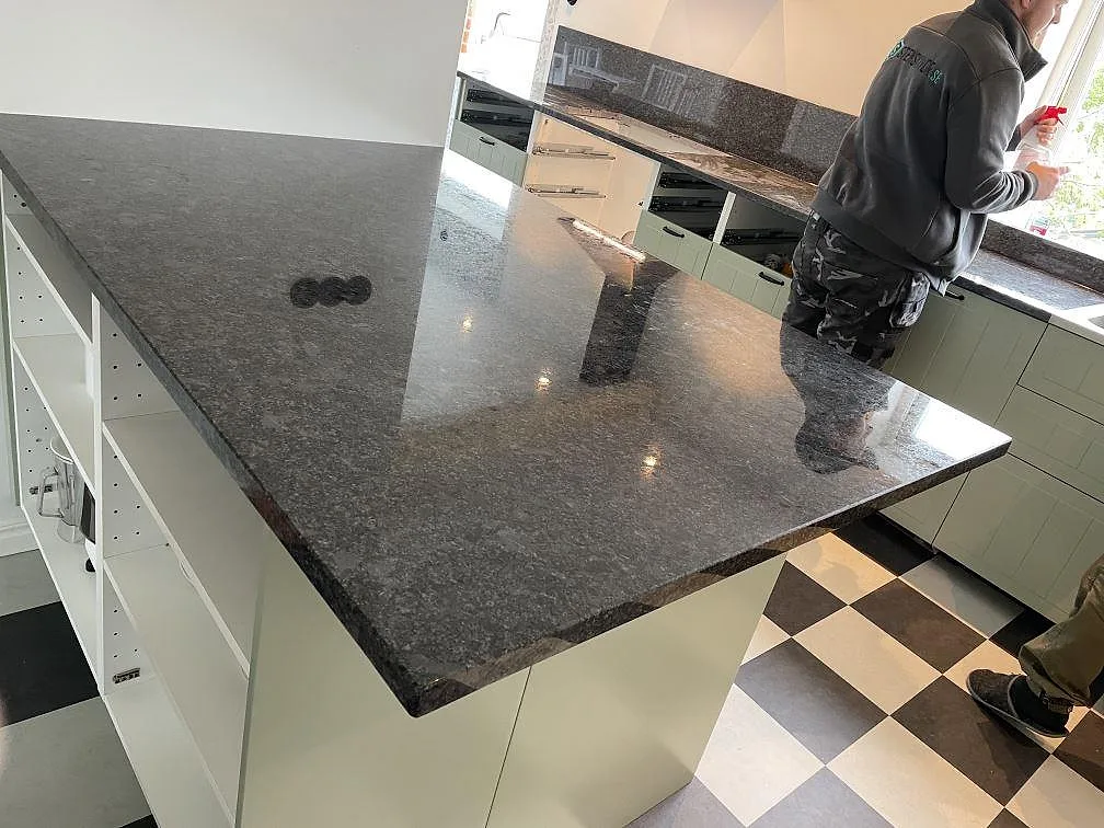 Stor arbetsyta i Steel Grey granit med polerad yta och speglingar i ett kök i Flyinge.