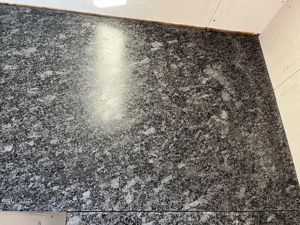Finkornig grå Steel Grey granit i matt bearbetning sedd snett ovanifrån i ett kök i Frillesås.