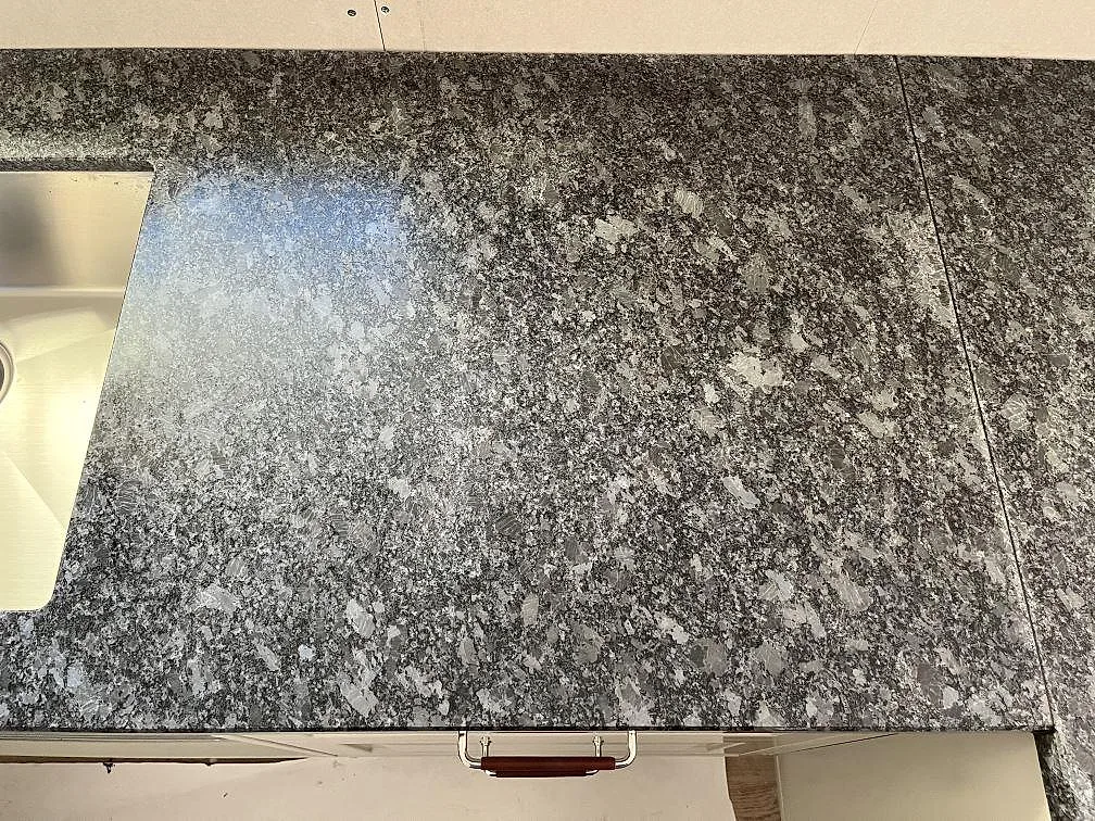 Matt grå Steel Grey granitbänkskiva med underlimmad rostfri diskho i ett kök i Frillesås.