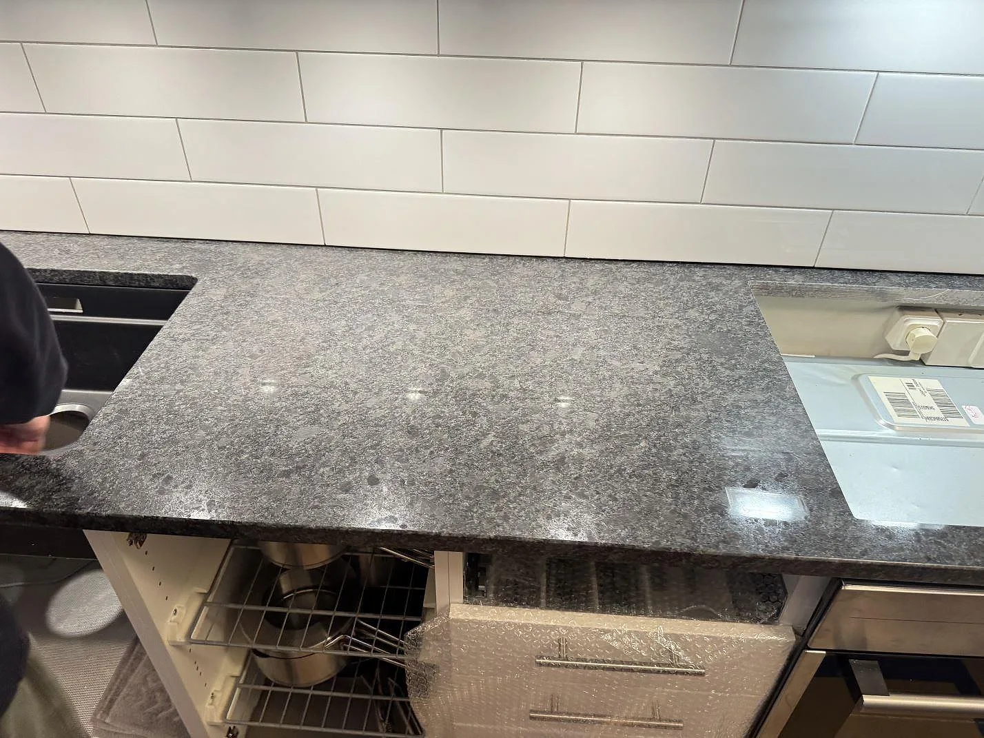 Rak arbetsyta i polerad Steel Grey granit mellan diskho och hällöppning under montering i Glommen.