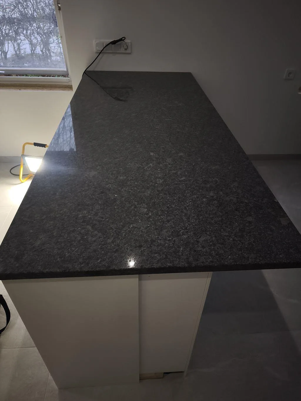 Närbild av polerad köksbänkskiva i Steel Grey granit med gråsvart kornighet och rak framkant i Helsingborg.