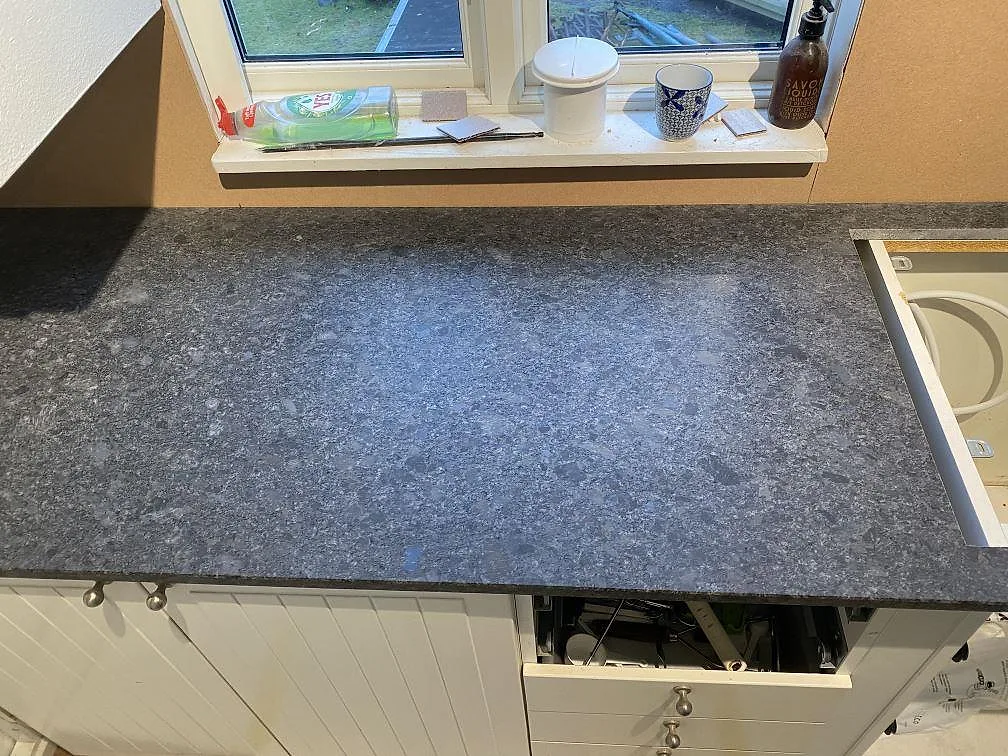 Matt Steel Grey granitbänkskiva vid köksfönstret i Hindås under pågående montering.