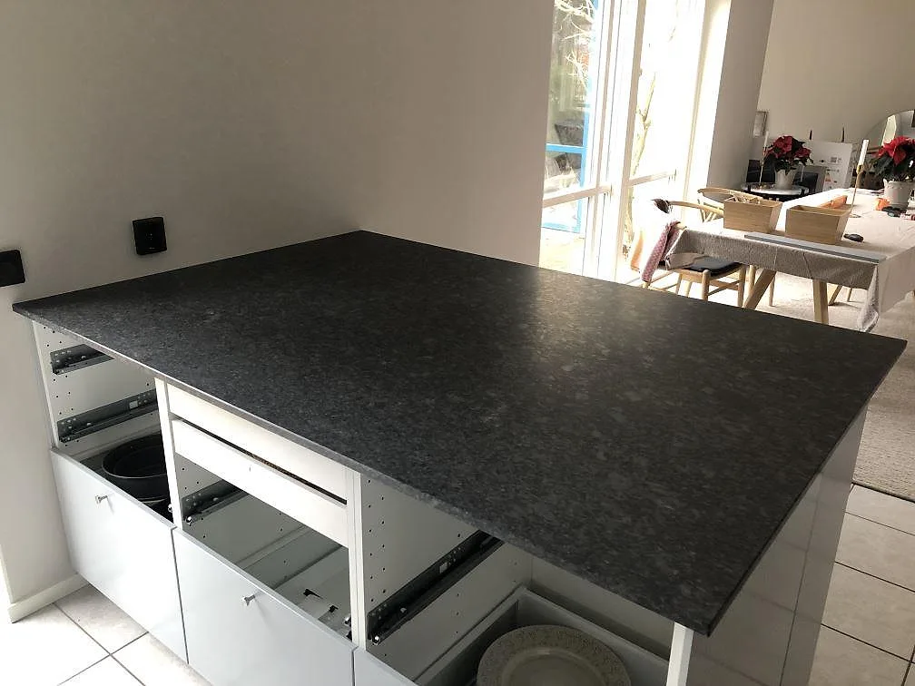 Matt Steel Grey granitbänkskiva monterad över köksstommar under montering i ett kök i Höllviken.