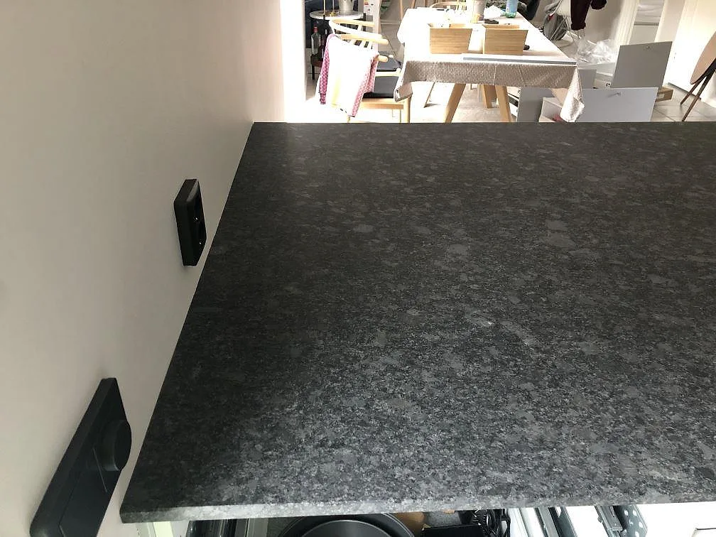 Närbild på den matta ytan och fina kristallstrukturen i Steel Grey granitbänkskiva i ett kök i Höllviken.