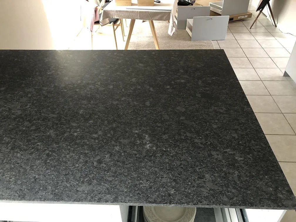 Steel Grey granitbänkskiva med rak fasad sedd ovanifrån i ett ljust kök i Höllviken.