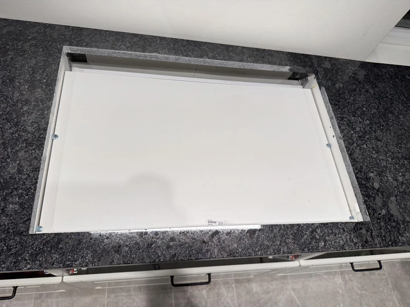 Polerad Steel Grey-granitbänkskiva med urtag täckt av skyddsskiva under montering i ett kök i Kävlinge.