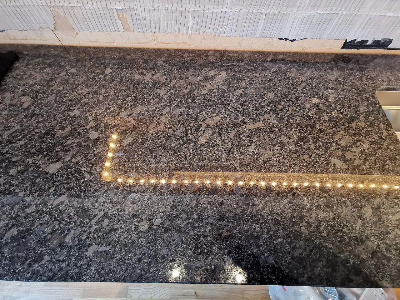 Närbild på den polerade Steel Grey-granitens spräckliga ådring på köksbänkskivan i Lindome.