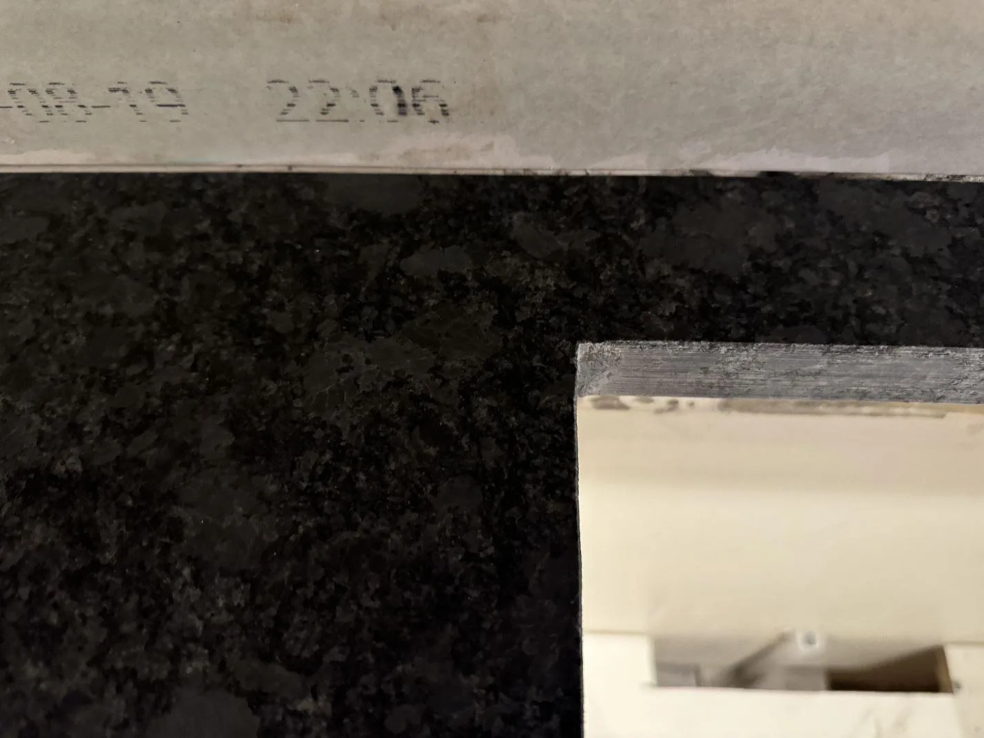 Detalj av polerad Steel Grey granit vid utskuren öppning och mörk stenstruktur i köket i Lund.