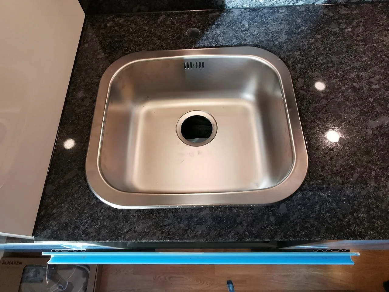 Rostfri diskho monterad i en polerad Steel Grey-bänkskiva i granit i ett kök i Malmö.