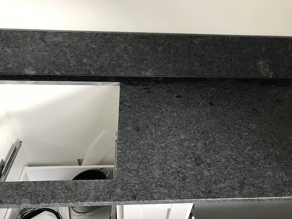 Köksbänkskiva i Steel Grey granit över monterade stommar i ett kök under inredning i Malmö.