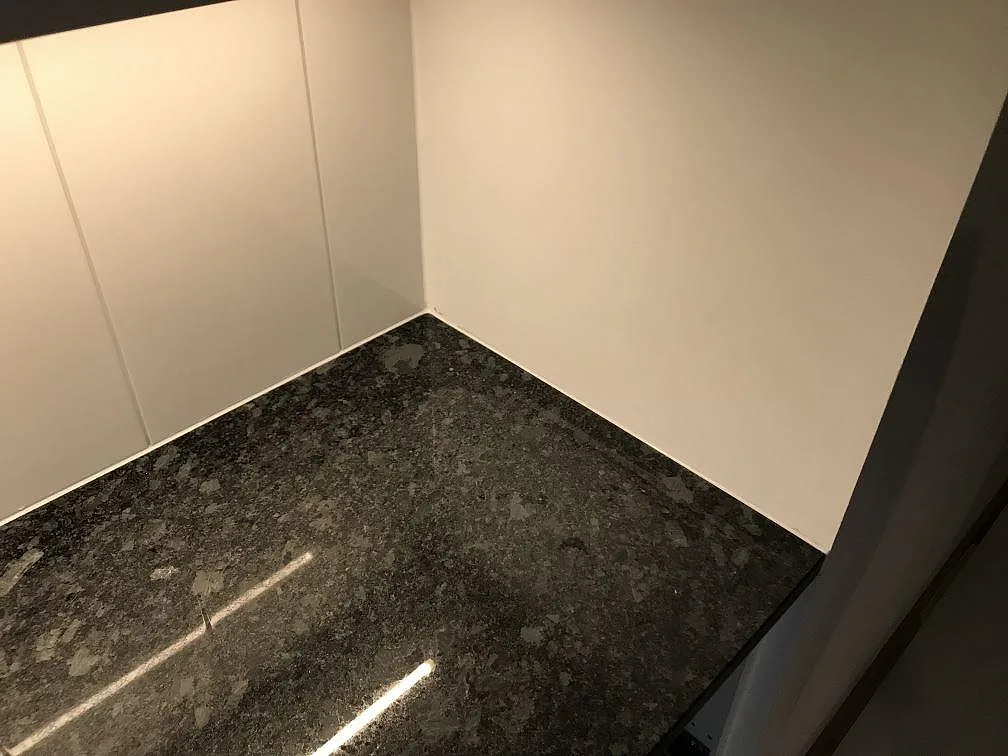 Polerad Steel Grey granitbänkskiva i hörnet mot vita väggar i ett kök i Malmö.