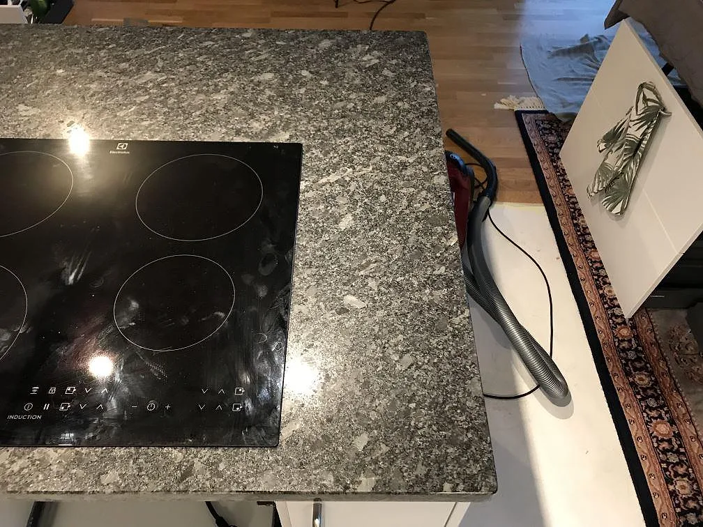 Polerad köksbänkskiva i Steel Grey granit med infälld induktionshäll i ett kök i Malmö.