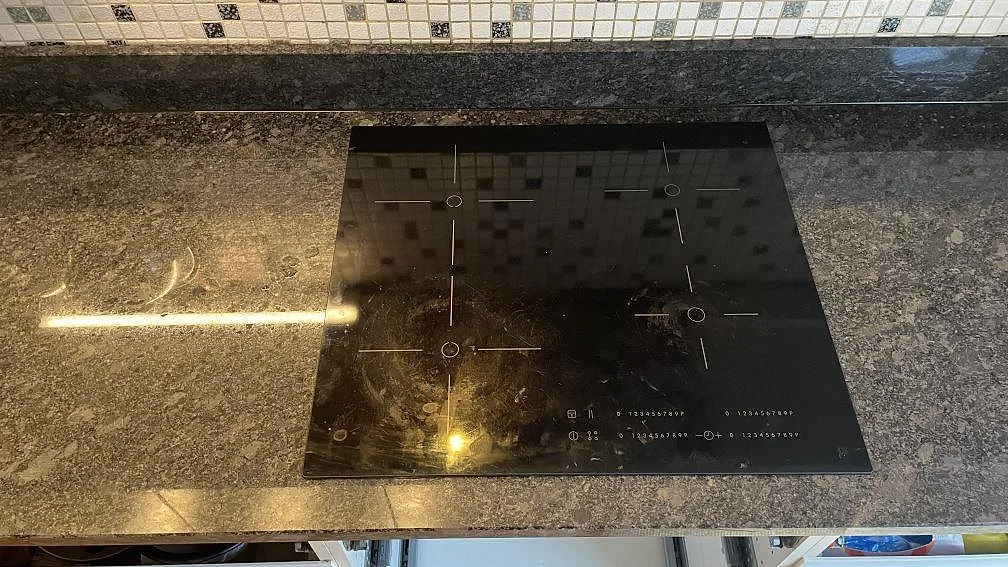 Detalj av urtag för häll i polerad Steel Grey granitbänk i ett kök i Mölndal.