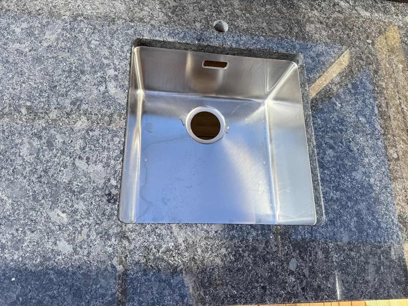 Diskho infälld i Steel Grey granit, med gråsvart stenstruktur och blank yta i Ramlösa.