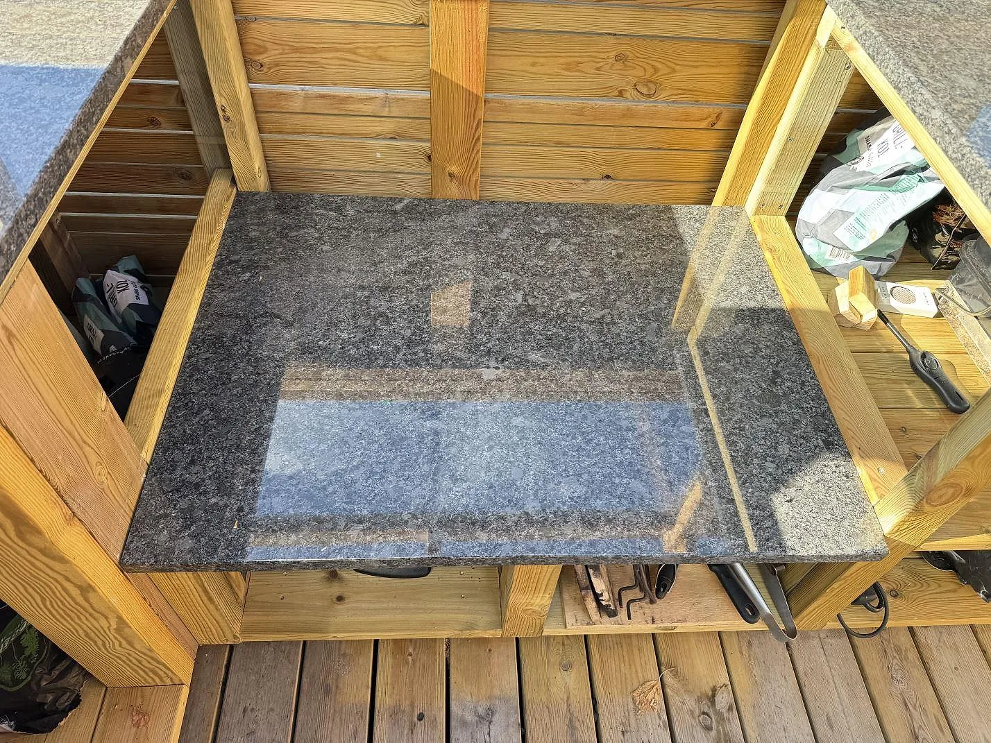 Mindre arbetsyta i Steel Grey granit under tak med trästommar och uteplatsgolv i Ramlösa.