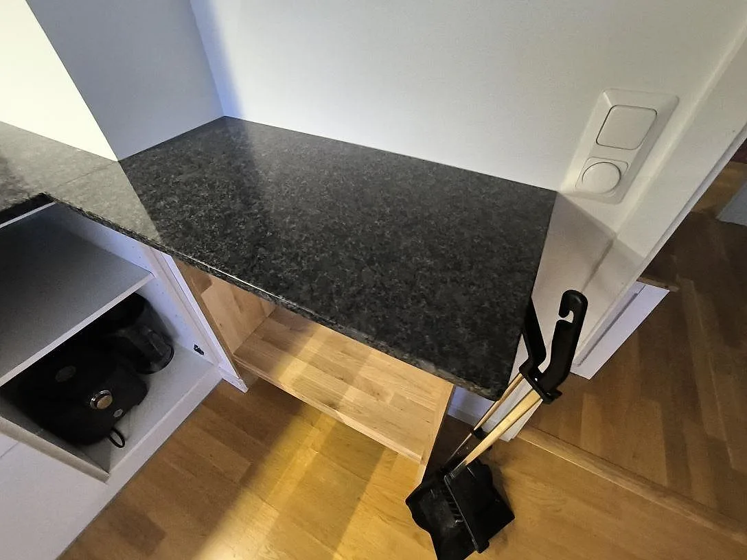 Detalj av höger returyta i polerad Steel Grey granit vid köksöppningen i Sundbyberg.