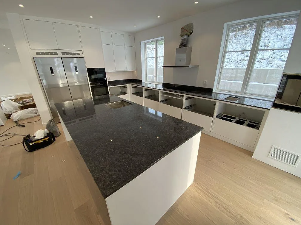 Kök med köksö och bänkskivor i polerad Steel Grey granit i Uddevalla, fotograferat under montering.