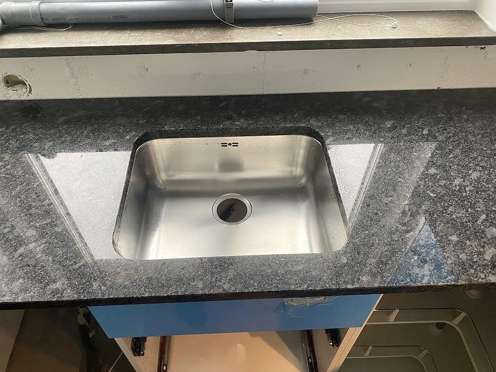 Underlimmad rostfri diskho i polerad köksbänkskiva av Steel Grey granit i Västra Frölunda.
