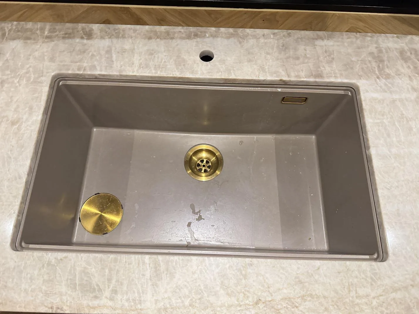 Topbild av underlimmad kompositdiskho med mässingsventil i Taj Mahal kvartsitbänkskiva i ett kök i Roskilde.