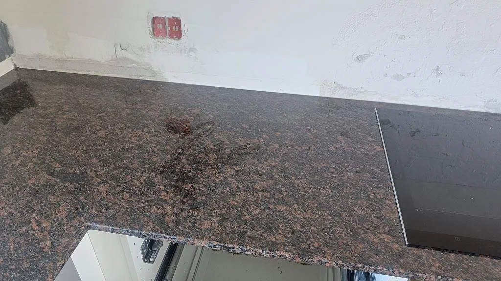 Polerad Tan Brown granitbänkskiva med häll åt sidan och synlig brun/svart stenstruktur i Kastrup.